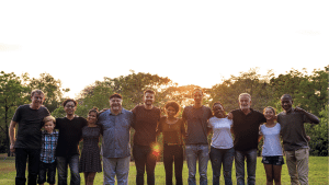 Diverse group of people holding hands at sunset