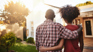 Couple standing in front of new house
