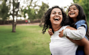 Smiling mother and daughter playing in the park