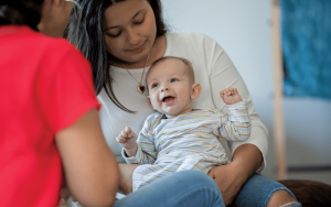 Young mother and smiling infant receiving a wellness visit